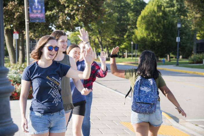 Students give each other high fives on the first day of classes.
